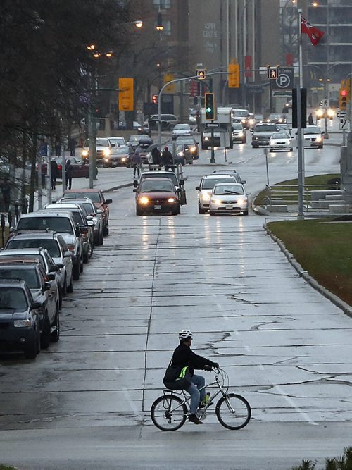 STDUP .A wet and windy ride for cyclist on Broadway Blvd at memorial Blvd.  on this wet , cold and windy , 5 degrees day .  NOV. 7 2014 / KEN GIGLIOTTI / WINNIPEG FREE PRESS