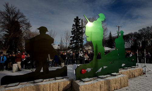 The sun glints off the war memorial at Valour Road and Sargent ave Tuesday morning as locals gather for the annual Remembrance Day service. See story. November 11, 2014 - (Phil Hossack / Winnipeg Free Press)