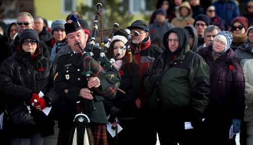 Corporal Kelly Fitzpatrick prepares to pipe at the war memorial at Valour Road and Sargent ave Tuesday morning for the annual Remembrance Day service. See story. November 11, 2014 - (Phil Hossack / Winnipeg Free Press)