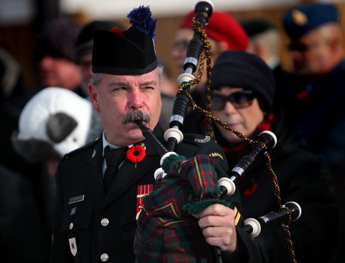 Corporal Kelly Fitzpatrick prepares to pipe at the war memorial at Valour Road and Sargent ave Tuesday morning for the annual Remembrance Day service. See story. November 11, 2014 - (Phil Hossack / Winnipeg Free Press)