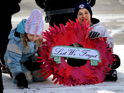 Robert Schulz 9 and his sister Chanel 6 wait at Sargent and Valour Road Tuesday morning with their home-made wreath for Remembrance Day. See story. November 11, 2014 - (Phil Hossack / Winnipeg Free Press)