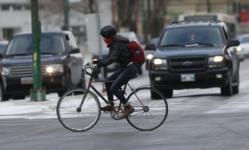 STDUP .A cyclist trying to stay warm crosses Memorial Blvd on a icy cool day . NOV. 12 2014 / KEN GIGLIOTTI / WINNIPEG FREE PRESS