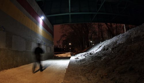 A pedestrian on an early evening walk on the River Walk that follows the Assiniboine River just east of the Donald Street Bridge where a sixteen-year-old girl was attacked by two men who have been arrested and charged with attempted murder and sexual assault.  141112 November 12, 2014 Mike Deal / Winnipeg Free Press