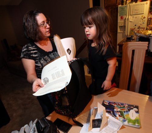 Jodean Adam, whose nine-year-old daughter Samantha is being bullied at Prince Edward School, sort Samantha's backpack after arriving home for the evening Wednesday. See story re: Bullied Dwarf. November 12, 2014 - (Phil Hossack / Winnipeg Free Press)