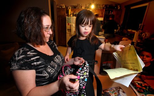 Jodean Adam, whose nine-year-old daughter Samantha is being bullied at Prince Edward School, sort Samantha's backpack after arriving home for the evening Wednesday. See story re: Bullied Dwarf. November 12, 2014 - (Phil Hossack / Winnipeg Free Press)