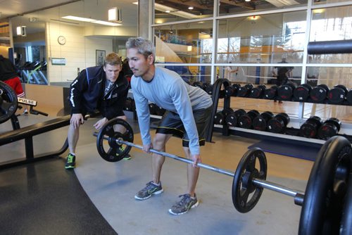 Wellness Centre. Howie Eugenio performs  hip hinge/straight leg deadlift while Karson Prost spots/coaches him. For this week's 49.8 section. BORIS MINKEVICH / WINNIPEG FREE PRESS November 13, 2014