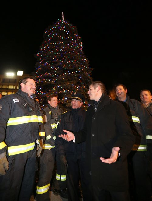 Mayor Brian Bowman speaks with firefighters and paramedics after he lit the Christmas Tree in front of City Hall, Friday, November 14, 2014. (TREVOR HAGAN/WINNIPEG FREE PRESS)