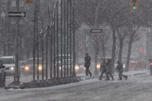 Pedestrians cross Portage Avenue as high gusts of wind continue to blow snow Sunday afternoon.  141116 November 16, 2014 Mike Deal / Winnipeg Free Press
