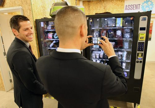 Jobs and the Economy Minister Kevin Chief shoots a picture next to, Mayor Brian Bowman- of a pair of dispensing machines that sell computer parts and tools at  Startup Winnipeg, Innovation Alley, third floor, 125 Adelaide St.  Announcing new investment in Startup Winnipeg and new grants  ( $300,000 from the Provice) to assist entrepreneurs Nov 17, 2014   (JOE BRYKSA / WINNIPEG FREE PRESS)