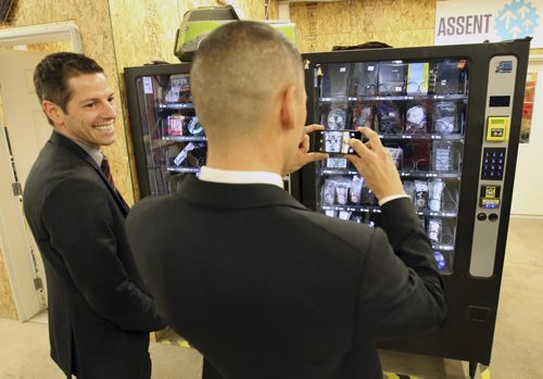 Jobs and the Economy Minister Kevin Chief shoots a picture next to, Mayor Brian Bowman-Ä®of a pair of dispensing machines that sell computer parts and tools at  Startup Winnipeg, Innovation Alley, third floor, 125 Adelaide St.  Announcing new investment in Startup Winnipeg and new grants  ( $300,000 from the Provice) to assist entrepreneursÄì Nov 17, 2014   (JOE BRYKSA / WINNIPEG FREE PRESS)