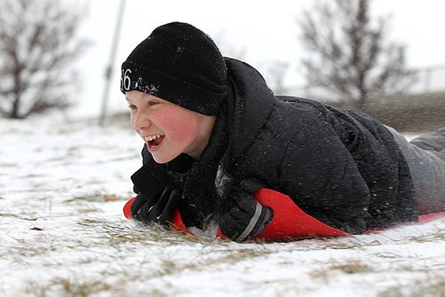 The Wilkinson family take a break Tuesday over the lunch hour from home schooling by going out sliding for the first time this winter at the "River Hill" which runs under the train tracks along Wellington Cresent.  Twelve year old Lowell is all smiles as he slides down the hill Tuesday.  Standup photo  Nov 18,  2014 Ruth Bonneville / Winnipeg Free Press