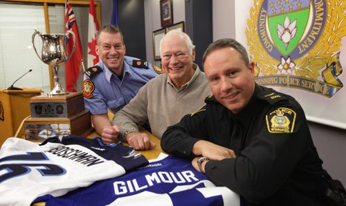Gregory Husson, Winnipeg Fire Paramedic Service, Ab Mcdonald, Winnipeg Jets legend and Constable Shaun Chornley , Winnipeg Police Service pose for a photo during kick-off announcing this year's Guns vs Hoses Charity Hockey Game which takes place at MTS Iceplex Friday at 7pm.  Tickets $10, rush seating.  Nov 20,  2014 Ruth Bonneville / Winnipeg Free Press