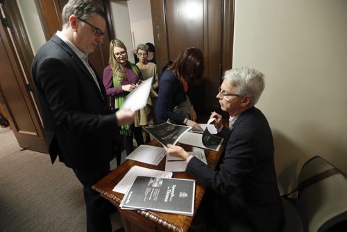 Dan Lett  and other reporters line up to  receive  and sign for copies of the Throne Speech from John Thorpe of Communications Service .  The  4th Session of 40th Manitoba legislature Throne Speech for the opening  fall session of the legislature . NOV. 20 2014 /KEN GIGLIOTTI / WINNIPEG FREE PRESS