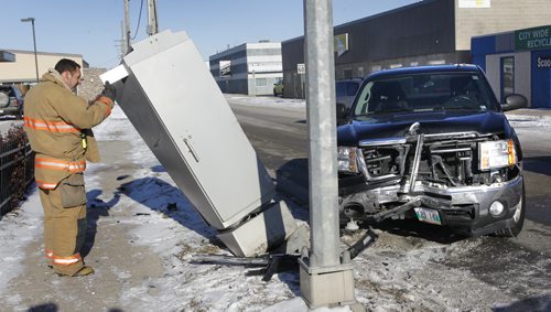 A Winnipeg Fire Fighter looks at the damaged electrical box after a two vehicle collison on Wall St. at Ellice Ave. Thursday afternoon. Paramedics checked out one person from a vehicle at the scene.    Wayne Glowacki / Winnipeg Free Press Nov. 20  2014