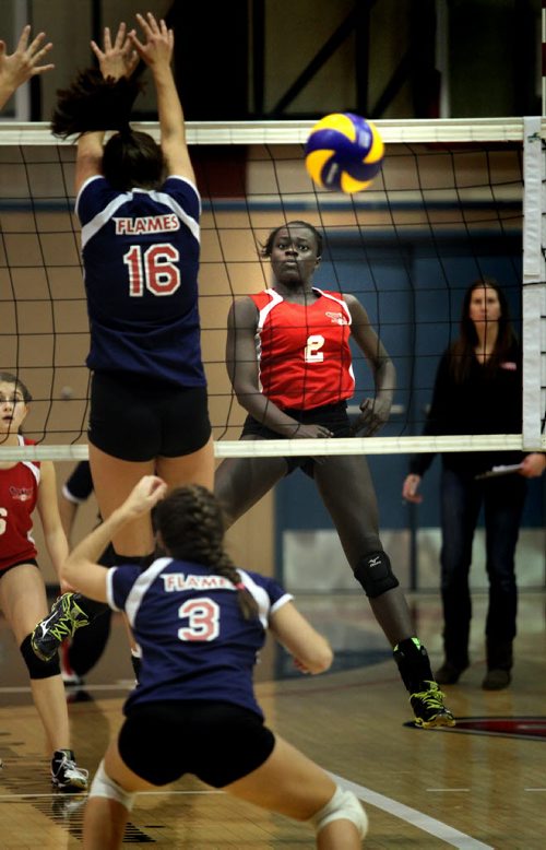 MBCI #2 Ayiya Ottogo watches as her "kill" sails past St Mary Flames defenders # 16Julia Tays and #3 Grace McDonald Monday evening at U of W during the MHSAA "AAAA" Volleyball Championship games. St Mary's Acadamy went on to win the title. November 24, 2014 - (Phil Hossack / Winnipeg Free Press)