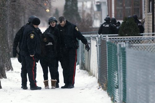 November 25, 2014 - 141125  -  A woman is detained as Winnipeg police emergency response unit wait to enter a home during a standoff on Toronto Street Tuesday, November 25, 2014. Police were called to a home on the block between Sargent and Ellice Tuesday afternoon. John Woods / Winnipeg Free Press