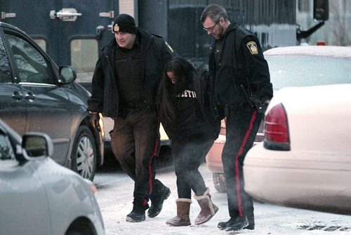 November 25, 2014 - 141125  -  A woman is detained by Winnipeg police during a standoff on Toronto Street Tuesday, November 25, 2014. Police were called to a home on the block between Sargent and Ellice Tuesday afternoon. John Woods / Winnipeg Free Press