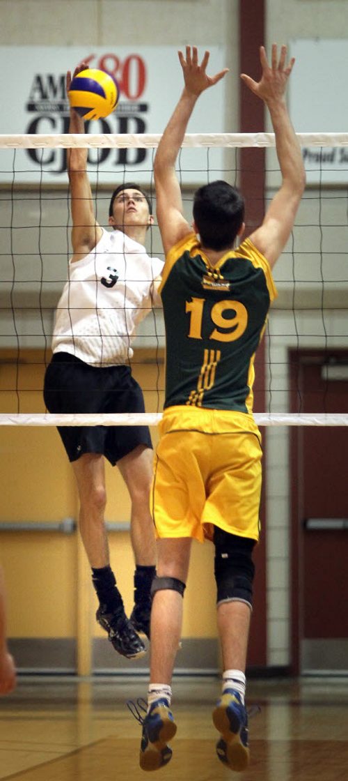 Steinbach Sabres #3 Stefan Lavalee spikes against Miles MacDonell's #19 Austyn Ducharme Thursday evening as the two teams met in MHSAA Volleyball semi-finals at the U of M's Investors Athletic Center. See Paul Wiecek's story. November 27, 2014 - (Phil Hossack / Winnipeg Free Press)
