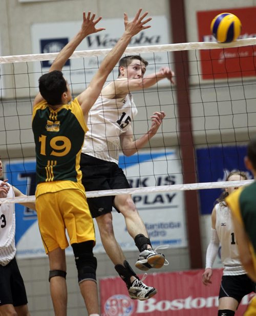 Steinbach Sabres #Bronson Teetaert spikes against Miles MacDonell's #19 Austyn Ducharme Thursday evening as the two teams met in MHSAA Volleyball semi-finals at the U of M's Investors Athletic Center. See Paul Wiecek's story. November 27, 2014 - (Phil Hossack / Winnipeg Free Press)