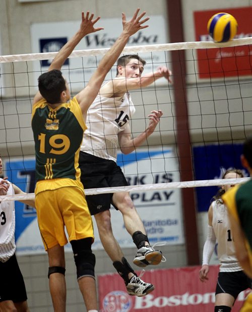 Steinbach Sabres #Bronson Teetaert spikes against Miles MacDonell's #19 Austyn Ducharme Thursday evening as the two teams met in MHSAA Volleyball semi-finals at the U of M's Investors Athletic Center. See Paul Wiecek's story. November 27, 2014 - (Phil Hossack / Winnipeg Free Press)