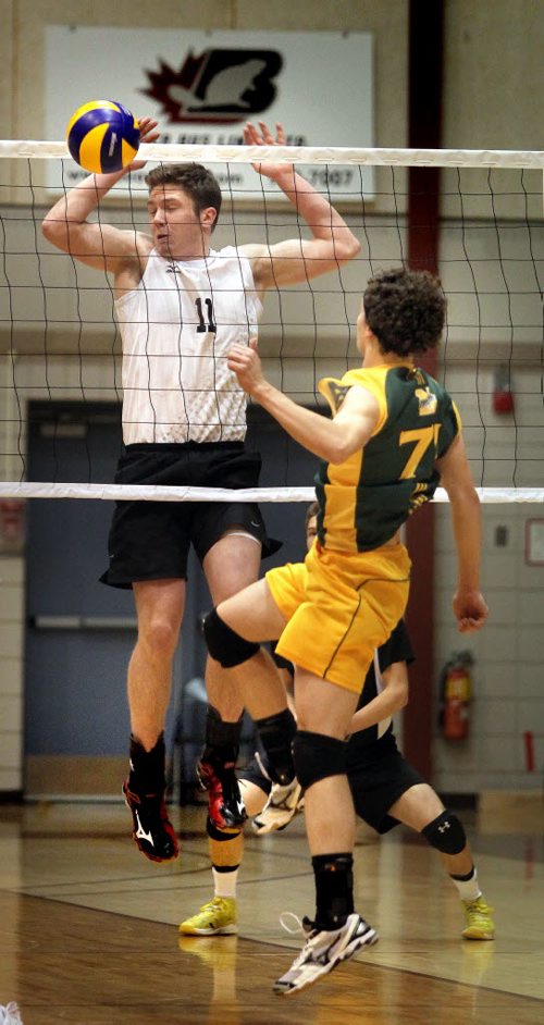 Steinbach Sabres #11 Jacob Loewen recoils after blocking Miles MacDonell's #71Serge Girouard Thursday evening as the two teams met in MHSAA Volleyball semi-finals at the U of M's Investors Athletic Center. See Paul Wiecek's story. November 27, 2014 - (Phil Hossack / Winnipeg Free Press)