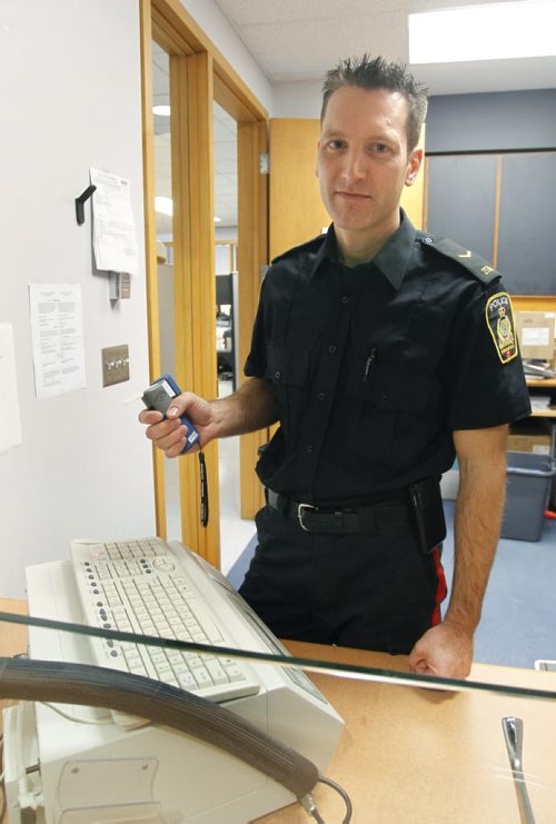 49.8 - IN CONVERSATION.  Const. Stephane Fontaine,  he is the impaired driving countermeasures coordinator for the Winnipeg Police Service. He is holding a portable device officers on the road use to check for alcohol, he is standing beside the breathalyzer in the police station.  Stephen Burns  story Wayne Glowacki / Winnipeg Free Press Dec.2  2014