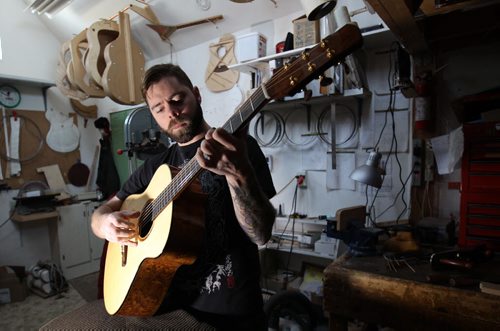 Jordon McConnells tries out one of his custom made acoustic guitars - For photo page Arts feature  Dec 02, 2014   (JOE BRYKSA / WINNIPEG FREE PRESS)