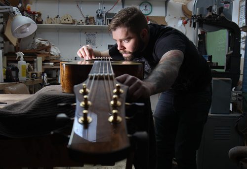 Jordon McConnell guitar maker in Winnipeg in his studio does some finishing touches on one of his custom made acoustic guitars - For photo page Arts feature  Dec 02, 2014   (JOE BRYKSA / WINNIPEG FREE PRESS)