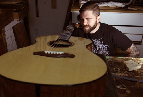 Jordon McConnell guitar maker in Winnipeg in his studio looks at one of his custom made acoustic guitars - For photo page Arts feature  Dec 02, 2014   (JOE BRYKSA / WINNIPEG FREE PRESS)