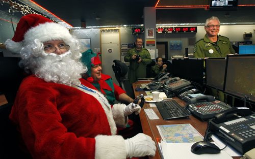 Santa Claus along with his Elf Eugene attended his annual pre-flight operational briefing Thursday at the Canadian NORAD Region HQ conducted by Lieutenant-Colonel Darrell Marleau, Combat Operations Division Chief (at right) to guarantee a safe sleigh and reindeer fight later this month. Canadian NORAD Region staff are in their final preparations for the 2014 NORAD Tracks Santa Operation. Wayne Glowacki / Winnipeg Free Press Dec.4  2014