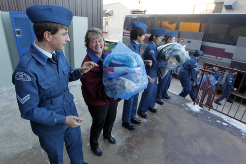 LOCAL - STANDUP - Siloam Mission's Director of Major Gifts & Corporate Relations Judy Richichi joins the chain line with 19 Air Cadets from Dauphin that grove into Winnipeg early this morning to deliver collected donations for the Siloam Mission. Most of the stuff was collected from the campground during cleanup of the Dauphin Countryfest over the last few years. BORIS MINKEVICH / WINNIPEG FREE PRESS December 5, 2014