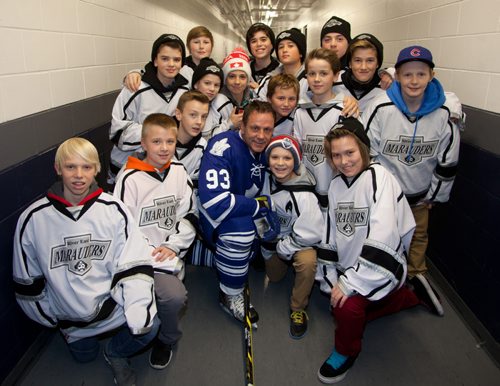The annual Guns vs. Hoses charity hockey game featuring the Winnipeg Police Patrolmen Hockey Club and the Winnipeg Fire Fighters hockey team took place at the MTS Iceplex on Nov. 21, 2014. Proceeds went toward paramedic Corey Schroeder, who was injured in an explosion in September. Pictured, from left, are former NHL star Doug Gilmour took some time between periods to pose with River East Marauders players who attended the game. (JOHN JOHNSTON/ WINNIPEG FREE PRESS)