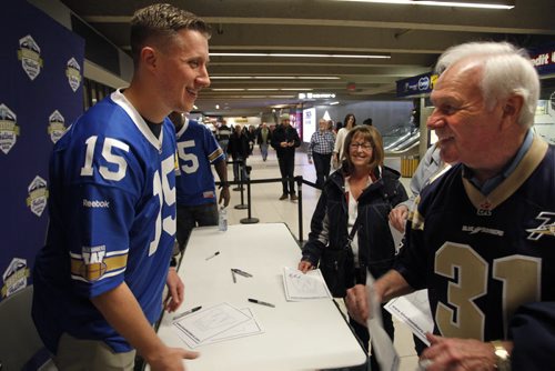 At right, Winnipeg Football Club Hall of Famer Ron "Pepe" Latourelle waited his turn to grab autographs from Winnipeg Blue Bomber players Clarence Denmark and  Drew Willy at left by 103rd Grey Cup headquarters and store that officially opened Friday in Winnipeg Square. Ron played for the Winnipeg Blue Bombers from 1955 to 1964, winning 4 Grey Cups. Wayne Glowacki / Winnipeg Free Press Dec.5 2014