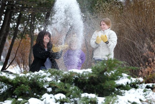 Lori Wiebe and her two daughters Ruby, 3yrs and Rachel 9yrs, enjoy the mild winter temperatures as they play in the snow near the formal garden at Assiniboine Park Saturday afternoon. Standup photo.  Dec 06,  2014 Ruth Bonneville / Winnipeg Free Press