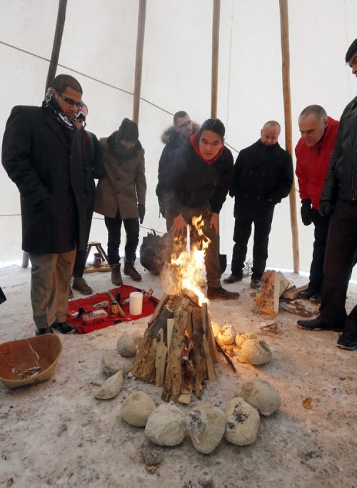 Stdup left Sachit  Mehra chair of the Downtown Biz and  Kevin Settee (right centre)   light the scared fire . DOWNTOWN IGNITES A SACRED FIRE IN HONOUR OF ASSEMBLY OF FIRST NATIONS CONFERENCE: DEC. 8 Downtown Winnipeg Äì Kevin Settee, an Ojibway Cree youth from Matheson Island and University of Winnipeg student, will be the Fire Keeper and Pipe Carrier of the Sacred Fire.A sacred fire will be lit on December 8 at 9:00 a.m. at the beginning of what will be a full-day of ceremonies in honour of the Assembly of First Nations (AFN) Special Chiefs Assembly.The  Sacred Fire is in honour of AFN Special Chiefs Assembly .The Pipe ceremony and lighting of Sacred Fire on Dec. 8 at 9:00 a.m. former Carlton Inn (St. Mary & Carlton)ÄúPrayers and intentions are offered through the fire with an offering of tobacco into the fire,Äù says Lisa Meeches, Executive Director of Manito Ahbee. ÄúThe sacred fire welcomes all to come and join and be a part of the ceremonies.ÄùKevin, along with other student volunteers and members of the Downtown Winnipeg BIZ will keep the fire burning 24 hours a day, until the AFN Special Chiefs Assembly concludes on Dec. 11.3,000 delegates of the Assembly of First Nations Special Chiefs Assembly will be arriving in  downtown Winnipeg.Äù. Dec. 8 2014 / KEN GIGLIOTTI / WINNIPEG FREE PRESS
