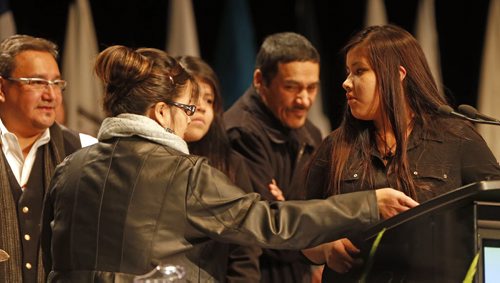Surrouned  by her family  and uncle Grand Chief David Harper ,(right) , her mother Julia (seen from back) , sister Rayne ,  father Ceasar .and (right) Rinelle Harper being honoured at AFN with an eagle feather at AFN Special Chiefs Assembly held at RBC Winnipeg Convention Dec. 9 2014 / KEN GIGLIOTTI / WINNIPEG FREE PRESS