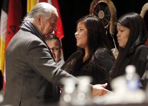 Regional Chief Bill Traverse gives Rinelle Harper an eagle feather and the event ended gave her some reassuring words after  she was  being honoured at AFN Special Chiefs Assembly held at RBC Winnipeg Convention  , her mother Julia left and sister Rayne right in photo .  Dec. 9 2014 / KEN GIGLIOTTI / WINNIPEG FREE PRESS