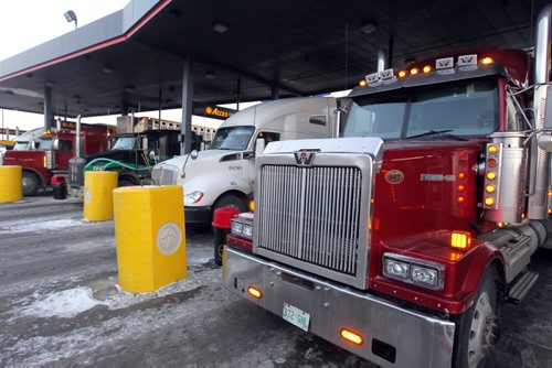 BIZ - Shot of a trucker filling up their rigs, the price showing $1.21.9 a litre, even though gasoline and crude oil have been plunging in the last few months. BORIS MINKEVICH / WINNIPEG FREE PRESS December 9, 2014