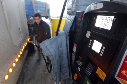 BIZ - Shot of a trucker filling up their rigs, the price showing $1.21.9 a litre, even though gasoline and crude oil have been plunging in the last few months. No ID on guy in photo. BORIS MINKEVICH / WINNIPEG FREE PRESS December 9, 2014