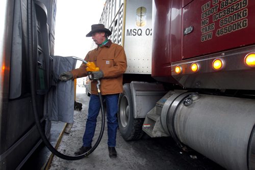 BIZ - Shot of a trucker filling up their rigs, the price showing $1.21.9 a litre, even though gasoline and crude oil have been plunging in the last few months. Trucker Daren McGuirk hauls cattle. BORIS MINKEVICH / WINNIPEG FREE PRESS December 9, 2014