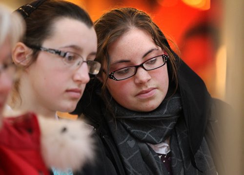 Rachel Kleinsasser (left)  and her cousin Krystal Kleinsasser (scarf) intently watch a multi-media display in the Canadian Journey's exhibit at the CMHR Wednesday afternoon during their free open house in honour of International Human Rights Day.   Dec 10,  2014 Ruth Bonneville / Winnipeg Free Press