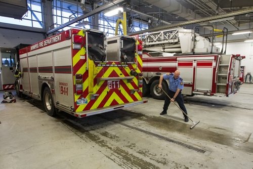 Keeping the garage clean after a truck returns from a call during a tour of the new Winnipeg Fire Paramedic Service Station 11 at Portage Avenue and Route 90. 141211 - Thursday, December 11, 2014 -  (MIKE DEAL / WINNIPEG FREE PRESS)