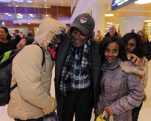 LOCAL - Zeleke Eliso Tuloro greets his family at Winnipeg James Armstrong Richardson International Airport. They are newcomers. Zeleke Eliso Tuloro meeting his family for the first time in 12 years  Teacher Zeleke Eliso Tuloro fled Ethiopia in 2002 as a political opposition party member targeted by military government  his wife and 3 kids stayed. Zeleke arrived in Winnipeg Dec. 12, 2012. In Wpg hes been working as a security guard to raise money to sponsor his family to join him. His family is youngest daughter Bethelihem (second from right) , son Nathenael (left), oldest daughter Kalkidan(behind far right), and wife named Zenebach(not in photo). BORIS MINKEVICH / WINNIPEG FREE PRESS December 11, 2014