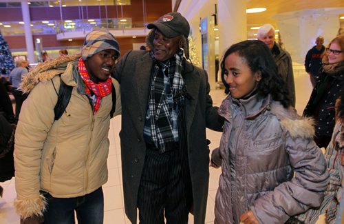LOCAL - Zeleke Eliso Tuloro greets his family at Winnipeg James Armstrong Richardson International Airport. They are newcomers. Zeleke Eliso Tuloro meeting his family for the first time in 12 years  Teacher Zeleke Eliso Tuloro fled Ethiopia in 2002 as a political opposition party member targeted by military government  his wife and 3 kids stayed. Zeleke arrived in Winnipeg Dec. 12, 2012. In Wpg hes been working as a security guard to raise money to sponsor his family to join him. His family in photo is son Nathenael (left) and youngest daughter Bethelihem. BORIS MINKEVICH / WINNIPEG FREE PRESS December 11, 2014
