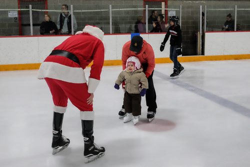 SKATE WITH SANTA - Kids and adults had the chance to strap on the blades and hit the ice with the Jolly Old Elf at Gateway Recreation CentreÄôs Skate with Santa on Sunday. Justin Durkin with his little girl Sloanne, 2, caught the eye of Santa while going around the rink. 141214 - Sunday, December 14, 2014 -  (MIKE DEAL / WINNIPEG FREE PRESS)