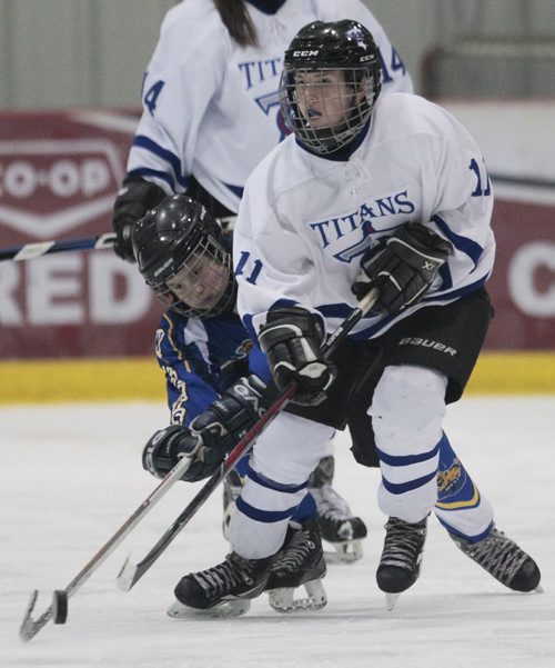 December 14, 2014 - 141214  -  Wesman Wildcats' Maddie Billaney (4) attempts to steal the puck from Bantam AA Titans' Amanda Fiebelkorn (11) at Hockey Manitoba's Project 100 Sunday, December 14, 2014. The weekend was a celebration of women's hockey in Manitoba. John Woods / Winnipeg Free Press