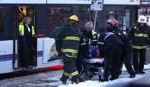 Winnipeg Fire Paramedics take an injured person from one the two Winnipeg Transit Buses that collided on Mapleglen Dr. Monday morning. Wayne Glowacki / Winnipeg Free Press Dec.15 2014