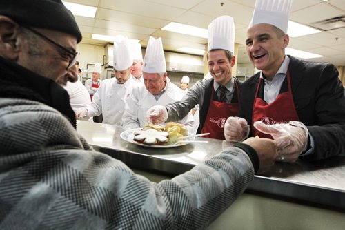 Students from Red River College's School of Hospitality and Culinary Arts prepared turkey dinner for about 500 at the Siloam Mission over the lunch hour Monday. Serving with the students were MLA Kevin Chief (right) and Mayor Brian Bowman (left).  141215 December 15, 2014 Mike Deal / Winnipeg Free Press