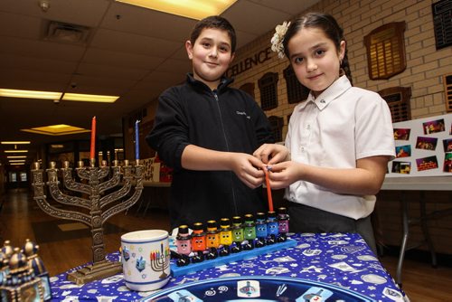 Daniel Broitman, 11, and his sister Michelle, 7, light a Chanukiyah candle at Gray Academy of Jewish Education. Tuesday night is the first night of Chanukah, an eight day celebration marking the miracle of light. 141215 - Monday, December 15, 2014 -  (MIKE DEAL / WINNIPEG FREE PRESS)