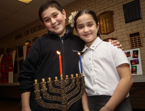 Daniel Broitman, 11, and his sister Michelle, 7, light a Chanukiyah candle at Gray Academy of Jewish Education. Tuesday night is the first night of Chanukah, an eight day celebration marking the miracle of light. 141215 - Monday, December 15, 2014 -  (MIKE DEAL / WINNIPEG FREE PRESS)